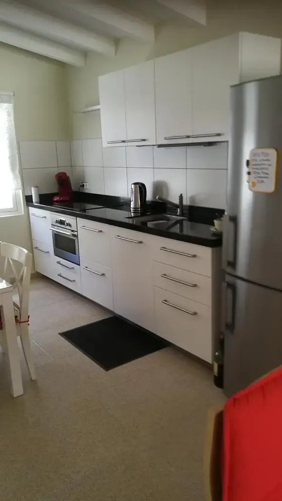 Witte keuken met koelkast en kookplaat
